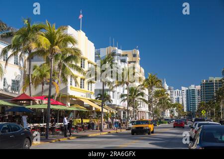 Miami Beach, Florida, USA. Blick nach Norden entlang des Ocean Drive, gelbes Taxi prominent, Miami Beach Architekturviertel, South Beach. Stockfoto