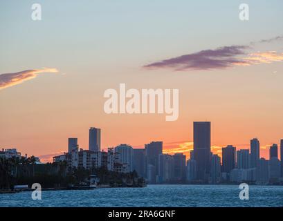 Miami Beach, Florida, USA. Blick vom South Pointe Park, South Beach, über die Biscayne Bay zu den Wolkenkratzern von Downtown Miami, Sonnenuntergang. Stockfoto