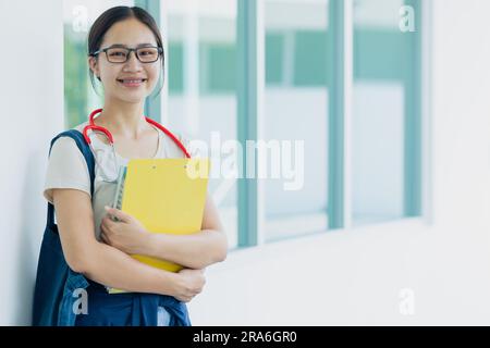 Glückliche Ärztin medizinische Universität Teenager Studentin auf dem Schulcampus genießen Studienausbildung asiatische Frau. Stockfoto