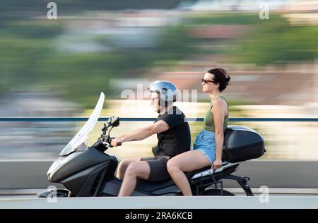 Belgrad, Serbien - 20. Mai 2023: Junger Mann, der an einem sonnigen Tag mit einer Sozius-Passagierin Motorrad fährt Stockfoto