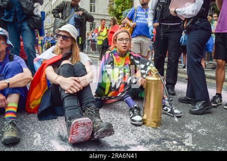 London, Großbritannien. 01. Juli 2023. Während der Demonstration sitzen Demonstranten und blockieren die Straße. Just Stop Oil-Aktivisten aus der LGBTQ-Gemeinde haben rosa Farbe besprüht und die Pride in London Parade blockiert, indem sie vor einem Coca-Cola-Truck saßen, der an der Parade teilnahm, um gegen Pride zu protestieren, der mit Industrien zusammenarbeitet, die mit der Klimakrise in Verbindung stehen, und um gegen Coca-Cola zu protestieren, Gilt als der weltweit größte Verursacher von Plastik. Kredit: SOPA Images Limited/Alamy Live News Stockfoto