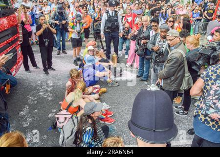 London, Großbritannien. 01. Juli 2023. Während der Demonstration sitzen Demonstranten und blockieren die Straße. Just Stop Oil-Aktivisten aus der LGBTQ-Gemeinde haben rosa Farbe besprüht und die Pride in London Parade blockiert, indem sie vor einem Coca-Cola-Truck saßen, der an der Parade teilnahm, um gegen Pride zu protestieren, der mit Industrien zusammenarbeitet, die mit der Klimakrise in Verbindung stehen, und um gegen Coca-Cola zu protestieren, Gilt als der weltweit größte Verursacher von Plastik. Kredit: SOPA Images Limited/Alamy Live News Stockfoto