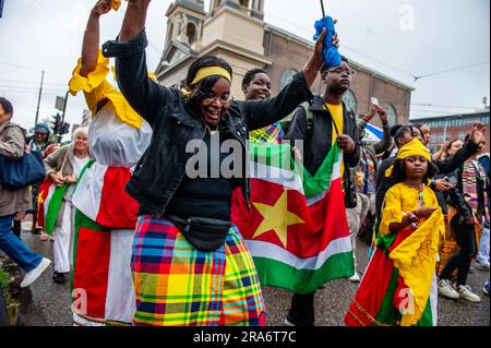 Amsterdam, Niederlande. 01. Juli 2023. Leute mit Flaggen aus Suriname werden beim Tanzen gesehen. Keti Koti wird traditionell mit einer gemütlichen und farbenfrohen Parade in traditioneller Kleidung namens Bigi Spikri eröffnet. Die Parade beginnt am stadtrat und endet am Slavery Monument Place in Oosterpark. Kredit: SOPA Images Limited/Alamy Live News Stockfoto