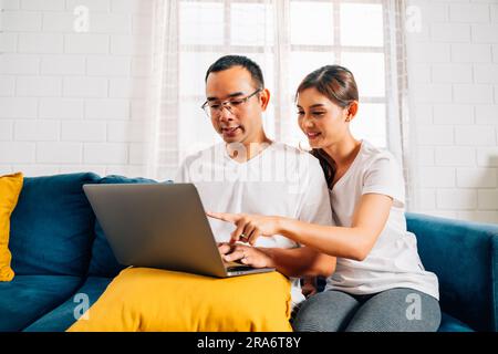 Ein Paar von Mann und Frau benutzte ein Notebook und surfte im Wohnzimmer im Internet Stockfoto