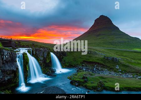 Kirkjufell Mountain, Island. Wunderschöner Sonnenuntergang über der isländischen Landschaft mit Bergen und Wasserfällen. Stockfoto