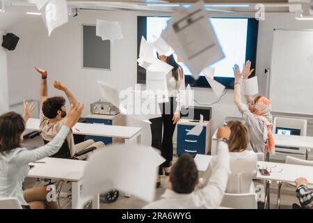 Multiethnische Geschäftsleute feiern Erfolge. Sie werfen Papiere in die Luft Stockfoto