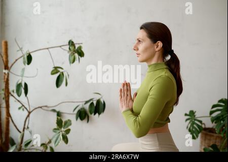 Seitliches Porträt einer jungen Frau, die Yoga-Achtsamkeitstechnik praktiziert Stockfoto