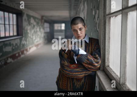 Obdachlose betrunkene junge Frau mit schwelender Zigarette Stockfoto