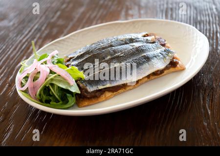 Studiofoto eines Tellers Sardinen auf Toast mit Salat im Gourmet-Stil. Konzept der spanischen Küche Stockfoto