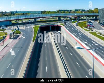 Mehrstöckige Autobahnkreuzung in Krakau, Polen. Eine Autobahn auf der obersten Ebene, die zweite im Tunnel, die Kehrtwende mit Ampeln und Stockfoto