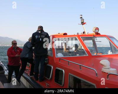 Die Besatzungsmitglieder des Kreuzfahrtschiffs „Heritage Adventurer“ helfen den Passagieren beim Einsteigen in eine der Ausschreibungen für einen Transfer von Schiff zu Land. Stockfoto