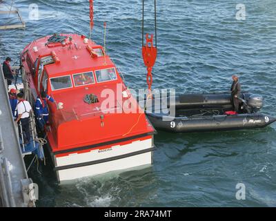 Der Transfer von Schiff zu Land von Fahrgästen von einem Kreuzfahrtschiff erfolgt durch ein Tender unter Aufsicht eines Besatzungsmitglieds in einem Zodiakboot. Stockfoto