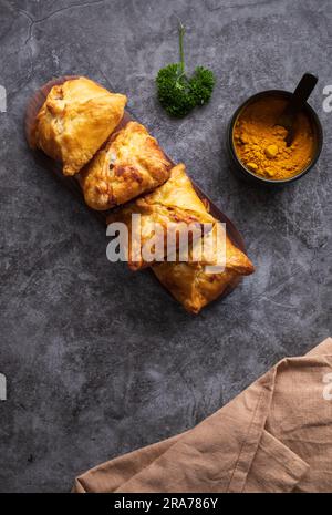 Kasachisch- und zentralasiatisches Küchenkonzept. Samsa oder Samosa oder Sambousak auf einem Teller. Samsa oder Samosa ist ein orientalisches Gericht, das mit Hackfleisch gefüllt wird, Stockfoto