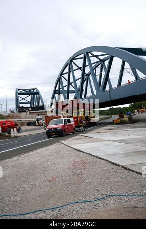 Eggolsheim, Deutschland. 01. Juli 2023. Zwei identische Schienenbrücken stehen nebeneinander: Eine ist bereits in Betrieb, die andere wird in Kürze installiert. Über der Autobahn A73 in der Nähe von Eggolsheim schiebt die Deutsche Bahn eine neue Zugbrücke, die etwa 90 Meter lang ist. Die Stahlkonstruktion wiegt 1200 Tonnen und wird durch millimeter Präzisionsarbeit mit sogenannten „selbstfahrenden modularen Transportern“ an ihren Bestimmungsort verlagert. Die Autobahn ist zu diesem Zweck vollständig geschlossen. Kredit: Pia Bayer/dpa/Alamy Live News Stockfoto