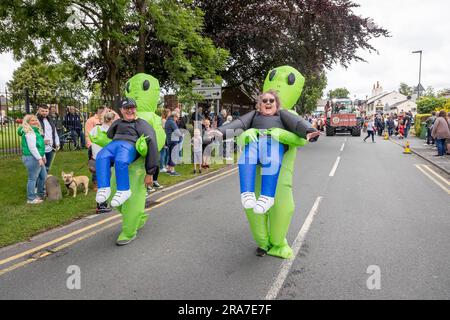 Juli 2023 - Croft Carnival Parade durch das Dorf. Mann und Frau in aufblasbaren Alien-Kostümen Stockfoto