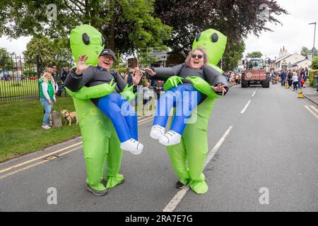 Juli 2023 - Croft Carnival Parade durch das Dorf. Mann und Frau in aufblasbaren Alien-Kostümen Stockfoto