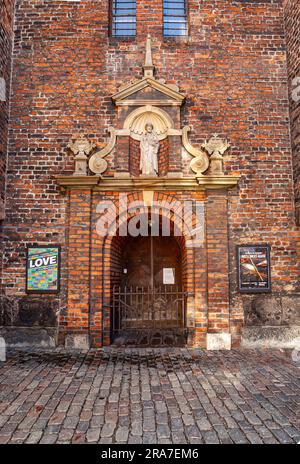 Kopenhagen, Dänemark - 15. September 2010: Nikolaj Kunsthallen, ehemals Nicholas-Kirche, rote Backsteinmauer mit heiliger Statue auf dem Histor Stockfoto