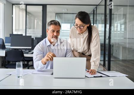 Zwei glückliche professionelle Kollegen diskutieren online über den Plan bei der Arbeit. Stockfoto