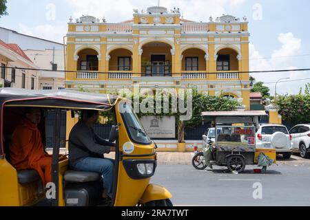 Phnom Penh, Kambodscha. 27. Juni 2023. Ein gelbes Tuk-Tuk passiert das UNESCO-Gebäude in Phnom Penh. Phnom Penh, die Hauptstadt Kambodschas, ist aufgrund ihrer Architektur im französischen Stil einst als „Perle des Orients“ bekannt und durchläuft einen raschen Wandel. Hauptsächlich durch chinesische Investitionen angetrieben, erlebt Phnom Penh von heute eine Welle neuer Entwicklungen, die wiederum zum Verlust eines Großteils seines architektonischen Erbes geführt hat. (Credit Image: © Oliver Raw/SOPA Images via ZUMA Press Wire) NUR ZUR REDAKTIONELLEN VERWENDUNG! Nicht für den kommerziellen GEBRAUCH! Stockfoto