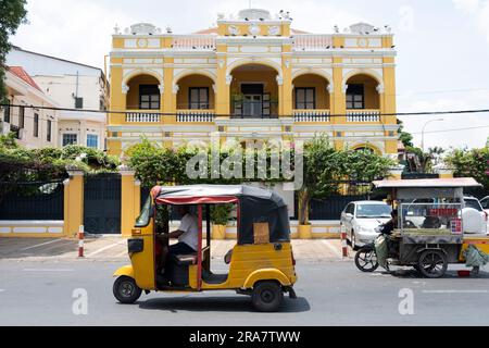 Phnom Penh, Kambodscha. 27. Juni 2023. Ein gelbes Tuk-Tuk passiert das UNESCO-Gebäude in Phnom Penh. Phnom Penh, die Hauptstadt Kambodschas, ist aufgrund ihrer Architektur im französischen Stil einst als „Perle des Orients“ bekannt und durchläuft einen raschen Wandel. Hauptsächlich durch chinesische Investitionen angetrieben, erlebt Phnom Penh von heute eine Welle neuer Entwicklungen, die wiederum zum Verlust eines Großteils seines architektonischen Erbes geführt hat. (Credit Image: © Oliver Raw/SOPA Images via ZUMA Press Wire) NUR ZUR REDAKTIONELLEN VERWENDUNG! Nicht für den kommerziellen GEBRAUCH! Stockfoto