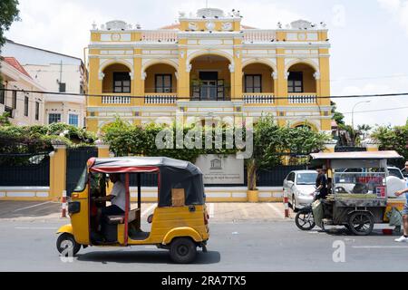 Phnom Penh, Kambodscha. 27. Juni 2023. Ein gelbes Tuk-Tuk passiert das UNESCO-Gebäude in Phnom Penh. Phnom Penh, die Hauptstadt Kambodschas, ist aufgrund ihrer Architektur im französischen Stil einst als „Perle des Orients“ bekannt und durchläuft einen raschen Wandel. Hauptsächlich durch chinesische Investitionen angetrieben, erlebt Phnom Penh von heute eine Welle neuer Entwicklungen, die wiederum zum Verlust eines Großteils seines architektonischen Erbes geführt hat. (Credit Image: © Oliver Raw/SOPA Images via ZUMA Press Wire) NUR ZUR REDAKTIONELLEN VERWENDUNG! Nicht für den kommerziellen GEBRAUCH! Stockfoto