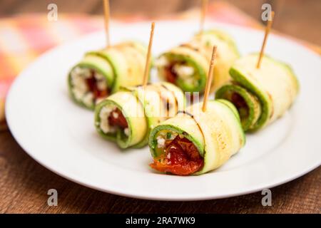 Zucchinirolle gefüllt mit sonnengetrockneten Tomaten und Ricotta, eine aromatische und gesunde Vorspeise oder Snack Option Stockfoto