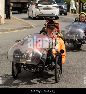 Portree, Isle of Skye, Schottland, Großbritannien. 5. Juni 2023 Liegen radelnde Radfahrer, die während einer Tour durch Skye durch das Stadtzentrum von Portree radeln. Schottland UK. Stockfoto