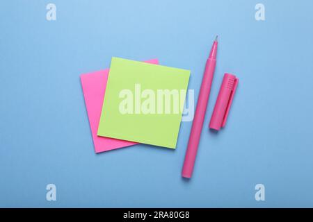 Papiernotizen und Farbmarker auf hellblauem Hintergrund, flach gelegt Stockfoto