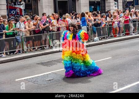 Ein Teilnehmer an der alljährlichen London Pride-Veranstaltung am 1. Juli 2023 auf Piccadilly in London in einem bunten Regenbogenkleid und einer Krone Stockfoto