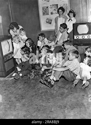 Vereinigte Staaten: 1949. Der Ausstellungsraum eines Müntz TV-Händlers, wo die Kinder die Shows sehen können, während die Eltern einkaufen. Stockfoto