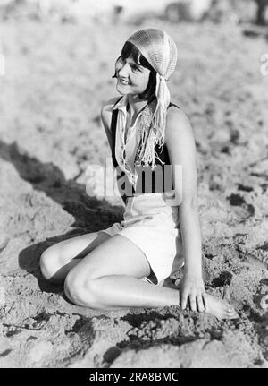 Los Angeles, Kalifornien: ca. 1929 Eine junge Frau am Strand in Venedig trägt die neueste modische Kopfbedeckung, die „Zigeunermütze“, die aus einem seidenähnlichen Netz besteht. Stockfoto