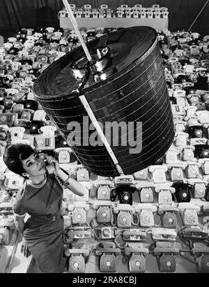 Los Angeles, Kalifornien: April 1965 Ein Mitarbeiter der Hughes Aircraft Company verwendet eines der 480 Telefone, die der Kommunikationssatelliten Intelsat 1 „Early Bird“ in zwei-Wege-Telefongesprächen zwischen Europa und Nordamerika übertragen kann. Stockfoto