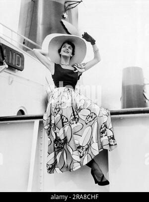 San Francisco, Kalifornien: April 1949 Model Gloria Cohan an an Bord eines Dampfschiffs mit einem sommerlichen „Gibson Bayh“-Design aus Seide. Bayh war ein maßgeschneiderter Modedesigner bei Gump's, dem Luxusmode- und Kaufhaus. Stockfoto