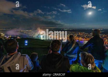 Dpatop - 01. Juli 2023, Rheinland-Pfalz / Hessen, Bingen / Rüdesheim: Die Menschen sehen das Feuerwerk vom Niederwalddenkmal aus, das von einer Passagier- und Autofähre auf dem Rhein zwischen Rüdesheim und Bingen gestartet wird. Das Feuerwerk „Rhein in Flammen“ findet jedes Jahr von Mai bis September auf den schönsten Abschnitten des Rheins statt: Am 1. Juli in Bingen und Rüdesheim. Foto: Andreas Arnold/dpa Credit: dpa Picture Alliance/Alamy Live News Stockfoto