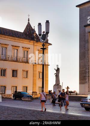 Statue mit Fußgängern im Abendlicht, Universität von Coimbra, UNESCO-Weltkulturerbe, Coimbra, Centro, Portugal Stockfoto