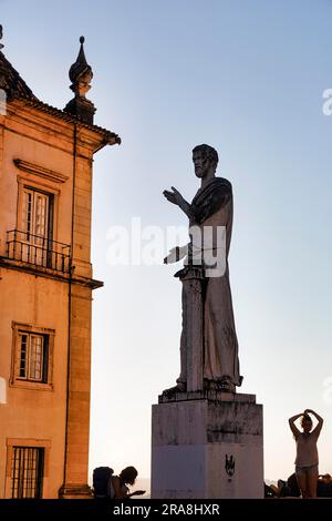 Statue mit Touristen, Silhouetten im Abendlicht, Universität von Coimbra, UNESCO-Weltkulturerbe, Coimbra, Centro, Portugal Stockfoto