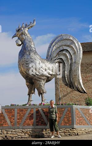 Frau vor Hahnenskulptur, Bresse, Ain, Rhone-Alpes, Frankreich Stockfoto