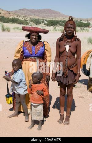 Herero Woman und Himba Woman mit Kindern, Damaraland, Namibia Stockfoto