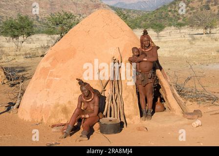 Himba-Frau vor einer Hütte, Kaokoveld, Namibia Stockfoto