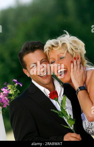 Der Mann schenkt der Frau eine rote Rose Stockfoto