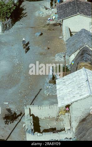 Urubamba, Peru - 19. April 1984: Blick aus der Vogelperspektive auf das inka-Dorf im Tal von Urubamba mit einer alten Frau, die auf einem Esel reitet. Stockfoto