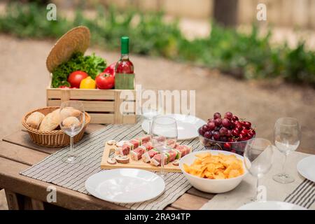 Auswahl an Sommer-BBQ oder Picknick-Speisen auf einem servierten Holztisch im Freien Stockfoto