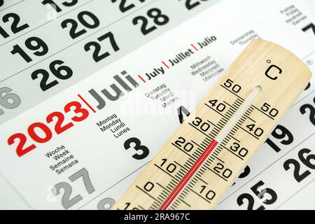 Deutscher Kalender Juli 2023 und Thermometer aus Holz 30 Grad Celsius Stockfoto