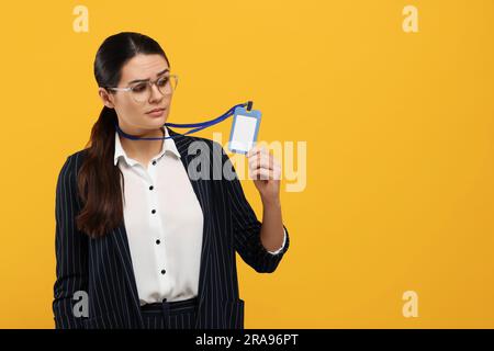 Frau mit vip-Pass-Abzeichen auf orangefarbenem Hintergrund. Platz für Text Stockfoto