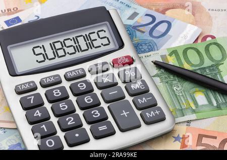 Taschenrechner mit Geld und Stift - Subventionen Stockfoto