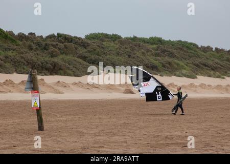 Ein Drachen-Surfer mit ihrem Drachen bergauf, nahe Weston Super Mare Stockfoto