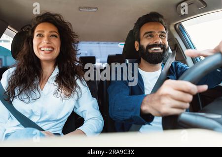Frontansicht Porträt eines glücklichen Mannes aus dem Nahen Osten, der ein Luxusfahrzeug fährt, und einer aufgeregten Frau, die auf dem Beifahrersitz sitzt Stockfoto