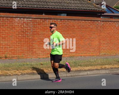 Kesgrave, Suffolk - 2. Juli 2023 : vom Laufverein Kesgrave Kruisers organisiertes Rennen zum Alan Brown Memorial 10k. Heißer Sommermorgen. Ein männlicher Läufer. Stockfoto