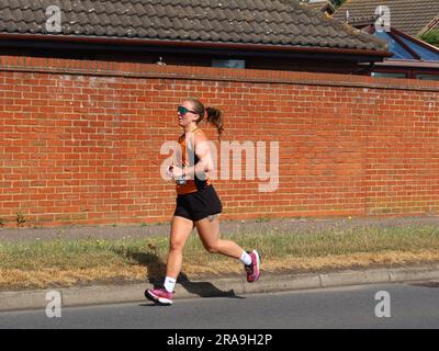 Kesgrave, Suffolk - 2. Juli 2023 : vom Laufverein Kesgrave Kruisers organisiertes Rennen zum Alan Brown Memorial 10k. Heißer Sommermorgen. Alleinstehende Läuferin. Stockfoto