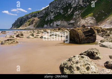 Am Fuße der Kreideklippen am Ende von Speeton Sands in Filey Bay an der Küste von North Yorkshire rostet der Kessel des alten Schiffs Stockfoto